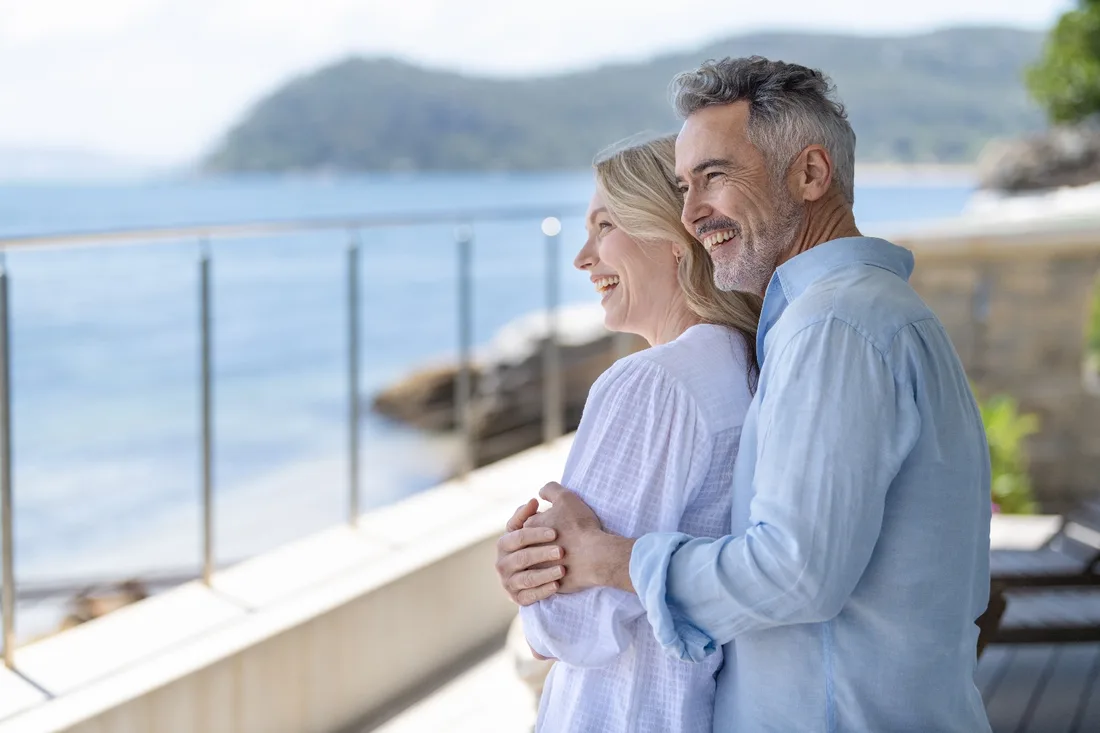 A couple smiling by the water